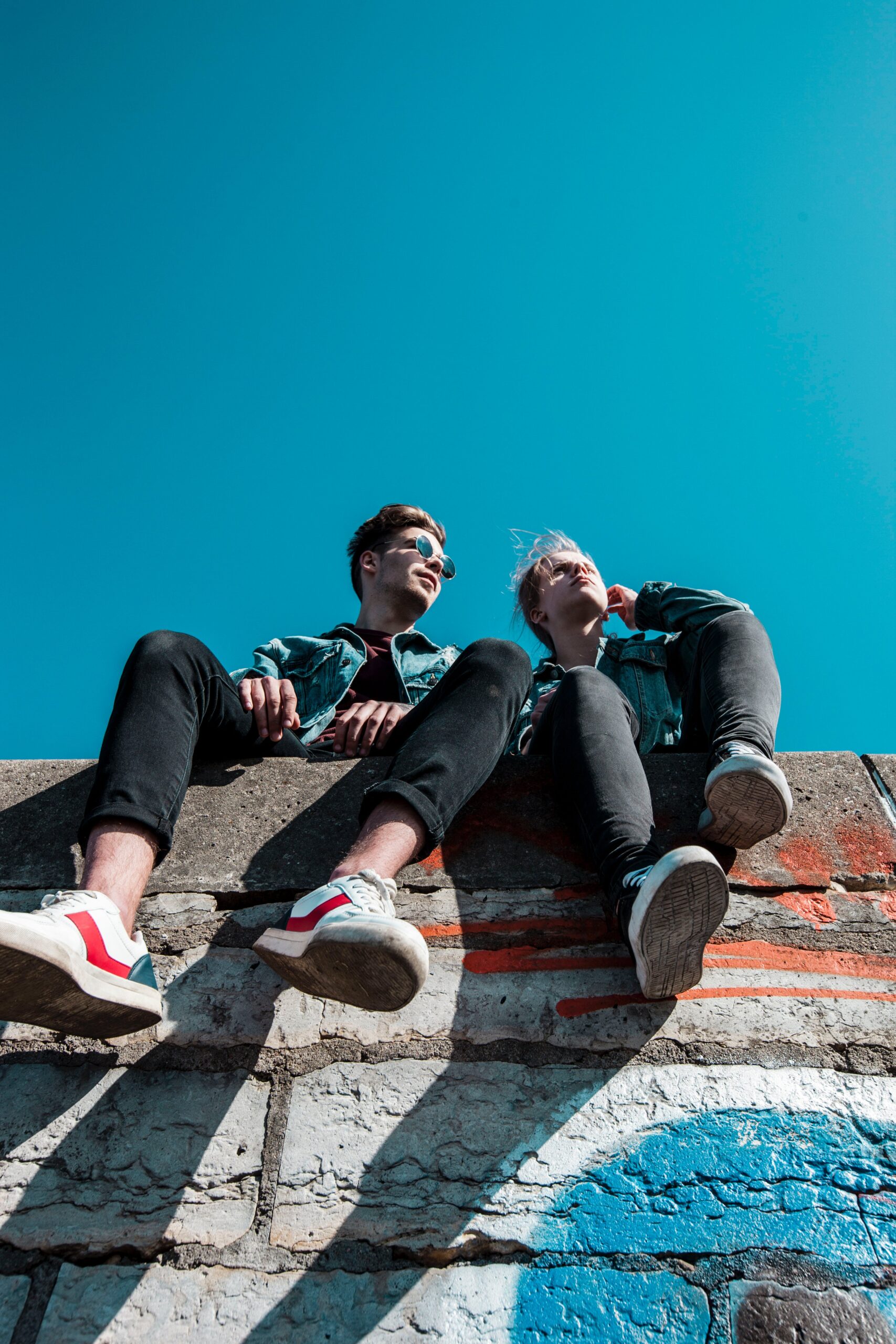 Deux jeunes personnes assises sur une corniche discutant de la manière dont JJE remplit sa promesse